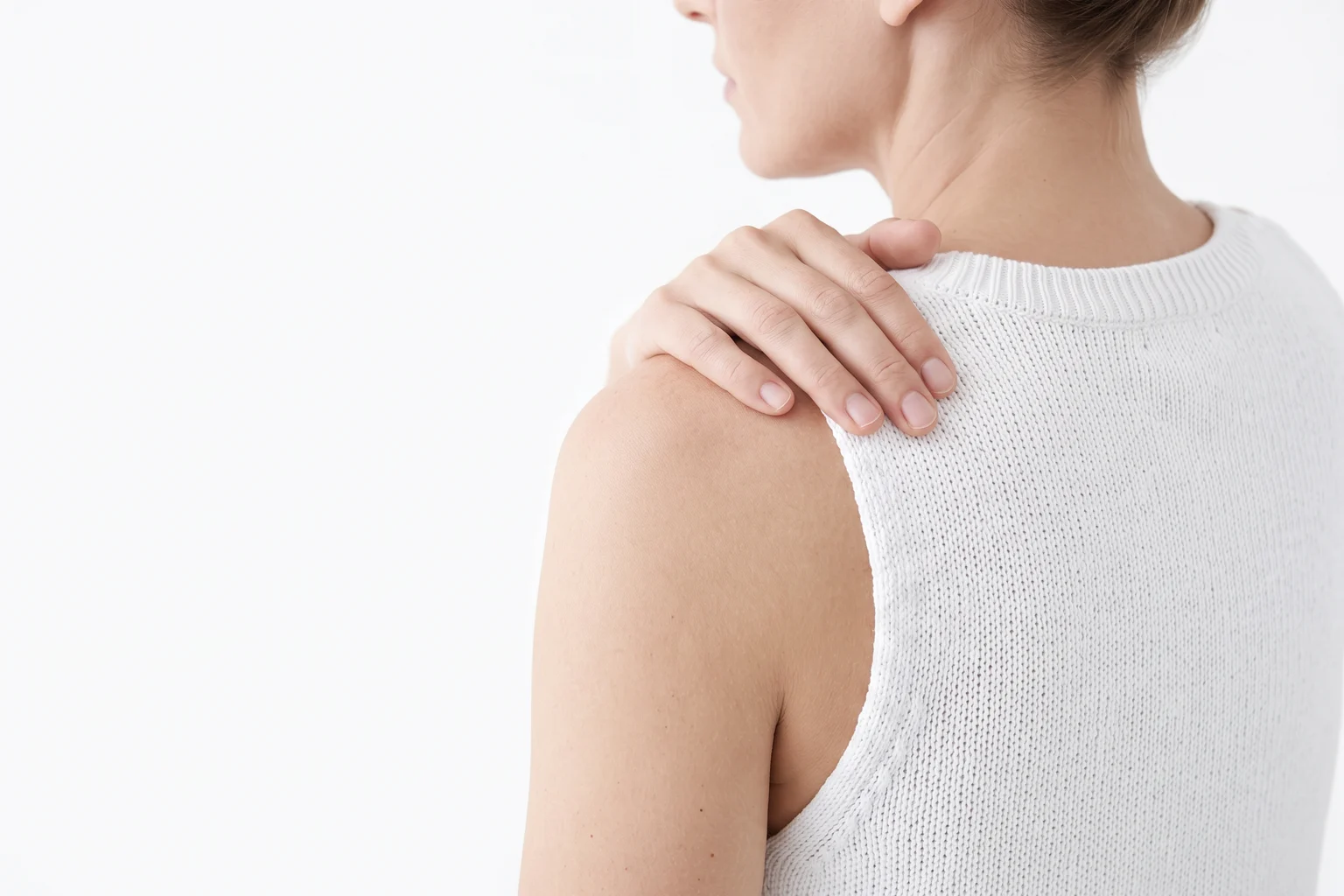 Woman gently resting her hand on her shoulder